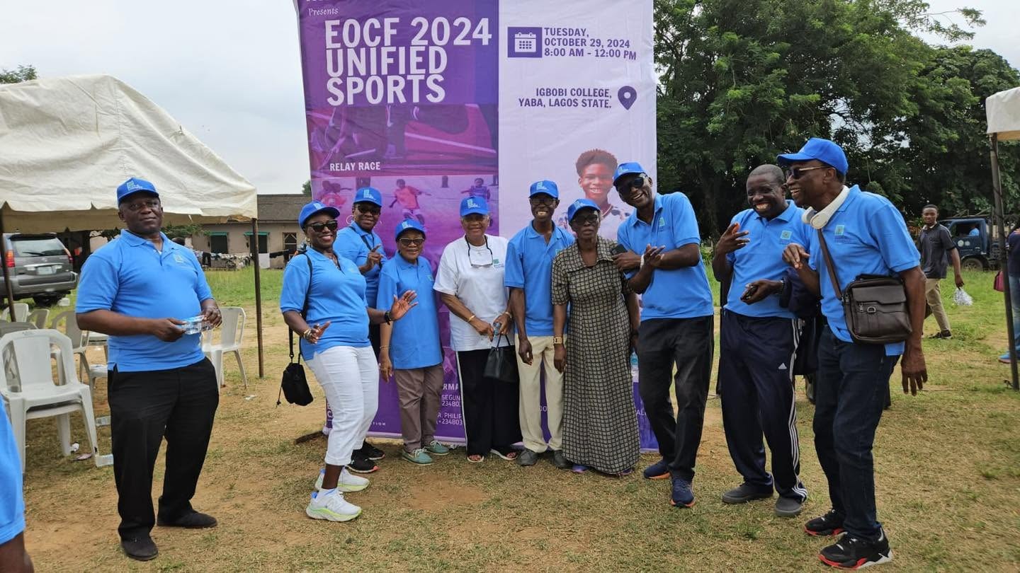 EOCF Unified Sports participants and supporters standing beside the 2024 event banner