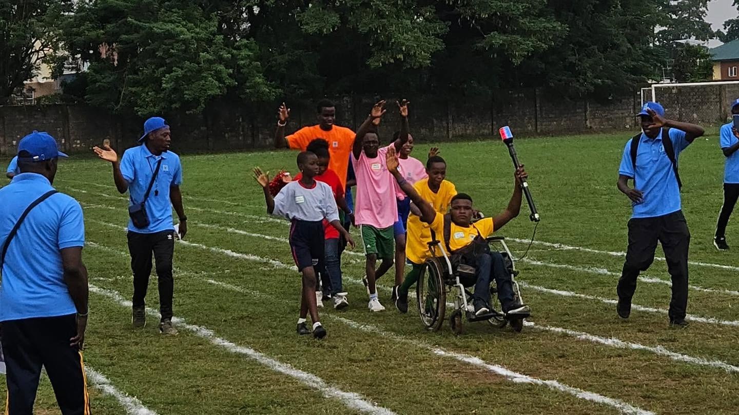 EOCF Unified Sports participants racing together on a grass field, including a wheelchair athlete